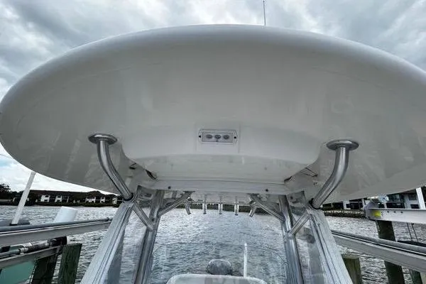 Slide: The Image of 2018 Regulator 23 Forward Seating boat with T-top, docked by the water. - 36