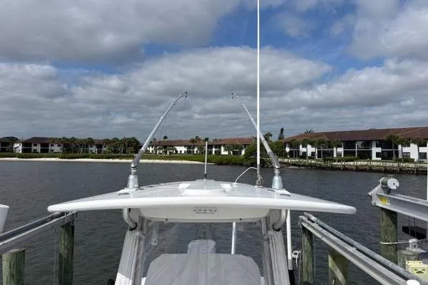 Slide: The Image of 2018 Regulator 23 Forward Seating boat docked by waterfront homes under cloudy sky. - 37
