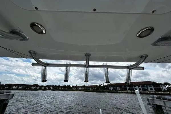 Slide: The Image of 2018 Regulator 23 Forward Seating boat with rod holders, overlooking a scenic waterfront. - 39