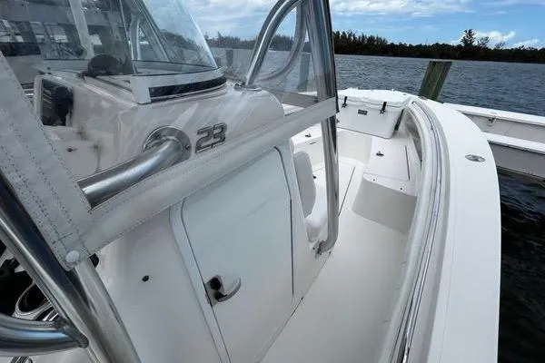 Slide: The Image of 2018 Regulator 23 Forward Seating boat, white interior, docked by the water. - 48