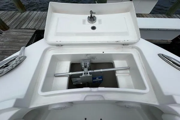 Slide: The Image of 2018 Regulator 23 Forward Seating boat anchor compartment, open lid, dockside view. - 56