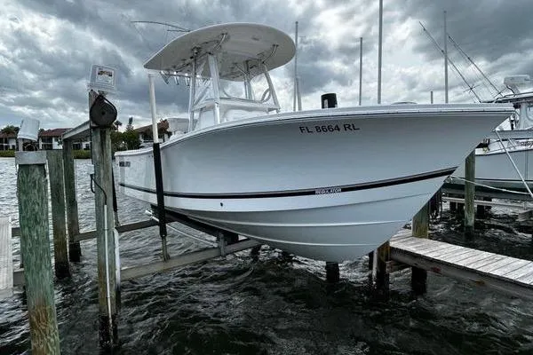 Slide: The Image of 2018 Regulator 23 Forward Seating boat docked on a lift under cloudy skies. - 61
