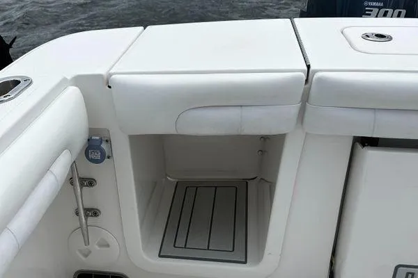Slide: The Image of 2018 Regulator 23 Forward Seating boat interior with storage compartment and cushioned seating. - 9