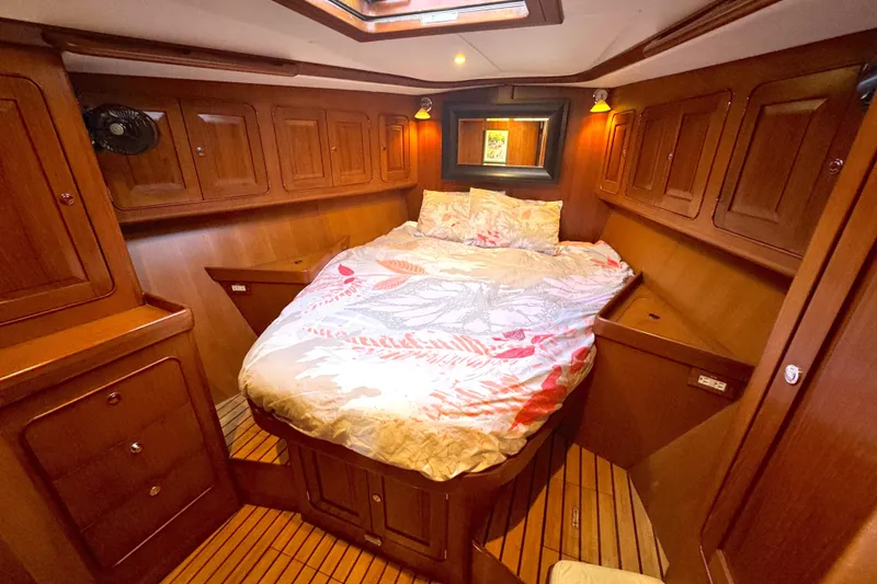 Slide: The Image of Luxurious 2009 Hylas 54 yacht cabin with wood paneling and cozy bedding. - 13