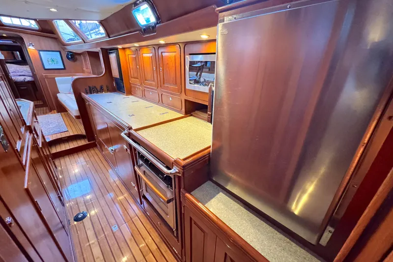Slide: The Image of Luxurious 2009 Hylas 54 yacht interior with wood cabinetry and modern appliances. - 19
