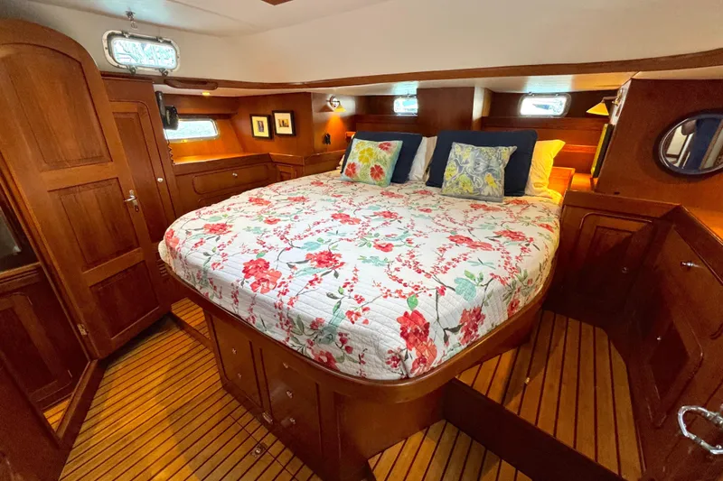 Slide: The Image of Luxurious 2009 Hylas 54 yacht cabin with floral bedding and rich wood interior. - 20