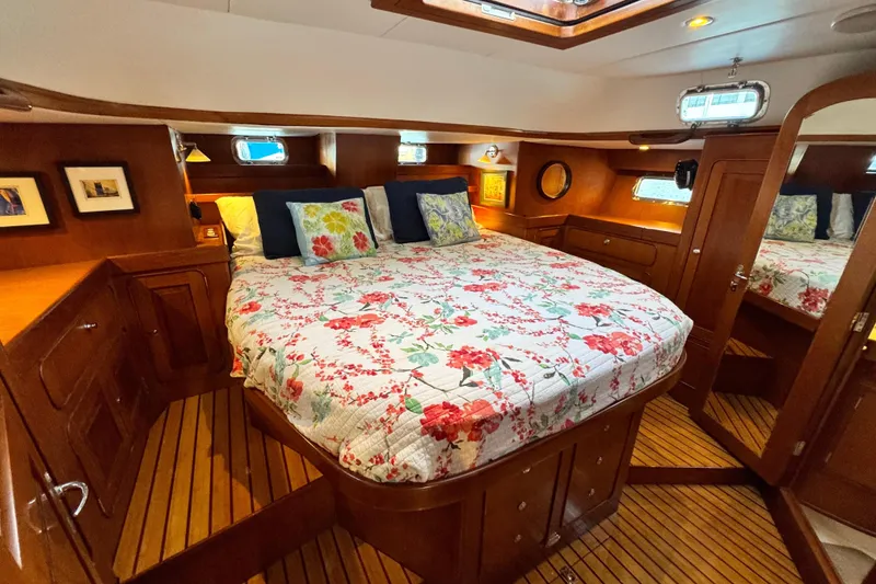 Slide: The Image of Luxurious 2009 Hylas 54 yacht cabin with floral bedding and wooden interior. - 21