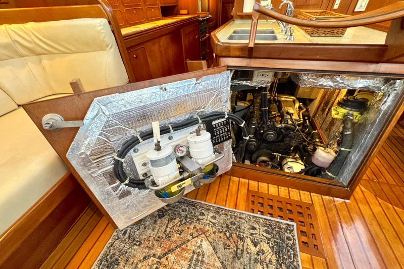 Slide: The Image of Engine compartment of a 2009 Hylas 54 yacht with visible filters and wooden interior. - 22