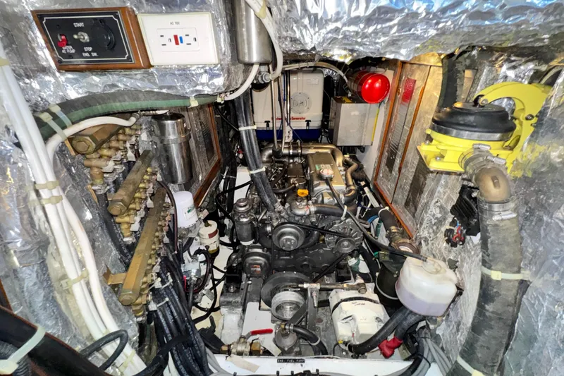 Slide: The Image of Engine room of a 2009 Hylas 54 yacht, showcasing mechanical components and wiring. - 23