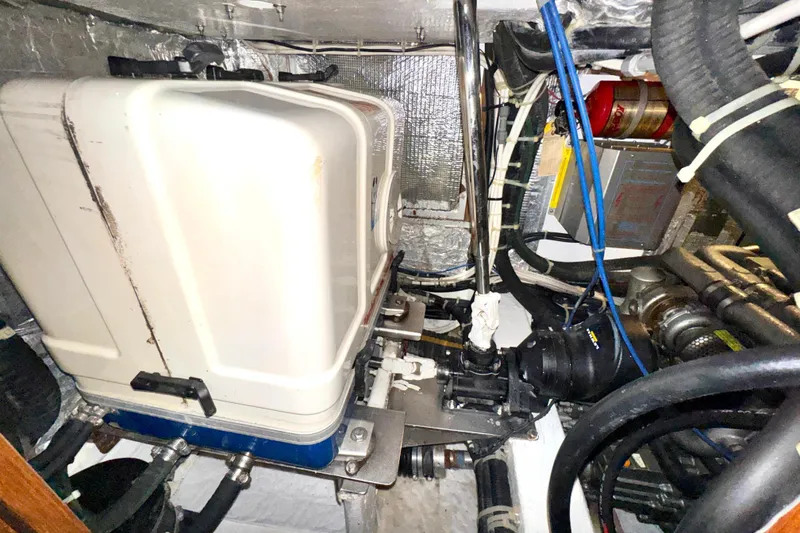 Slide: The Image of Engine room of a 2009 Hylas 54 yacht, showcasing mechanical components and wiring. - 25