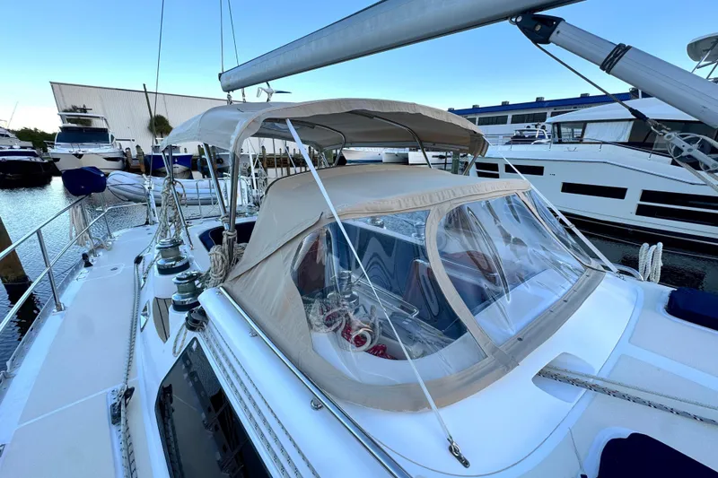 Slide: The Image of 2009 Hylas 54 sailboat docked, featuring a covered cockpit and sleek design. - 8