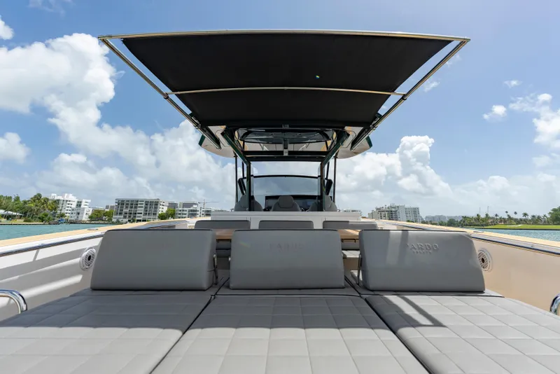 Slide: The Image of 2024 Pardo Yachts 43 luxury yacht with sunbathing deck and canopy, docked near modern buildings. - 39