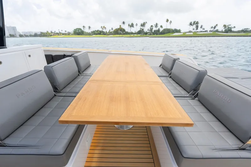 Slide: The Image of Luxury seating area on 2024 Pardo Yachts 43, featuring elegant wooden table and cushioned benches. - 44