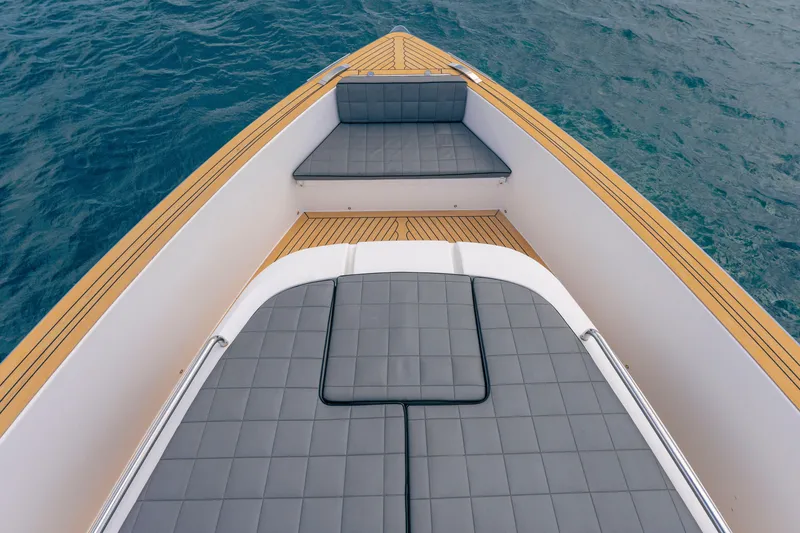 Slide: The Image of 2024 Pardo Yachts 43 deck with cushioned seating and teak flooring on the water. - 52