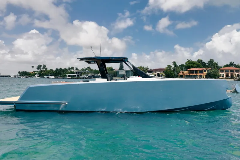 Slide: The Image of 2024 Pardo Yachts 43 in blue, cruising on clear turquoise waters under a partly cloudy sky. - 7