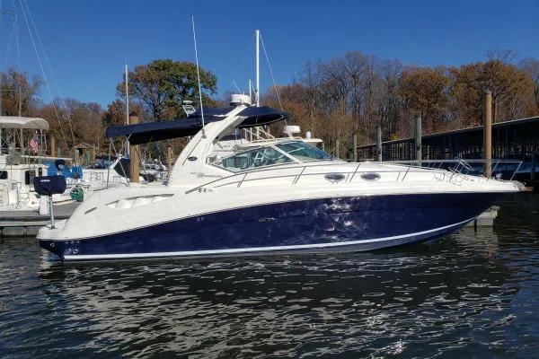 The Image of 2006 Sea Ray 340 Sundancer yacht docked in a marina, clear blue sky. - 1