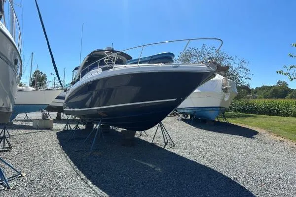 Slide: The Image of 2006 Sea Ray 340 Sundancer boat on stands in a gravel lot under clear blue sky. - 5
