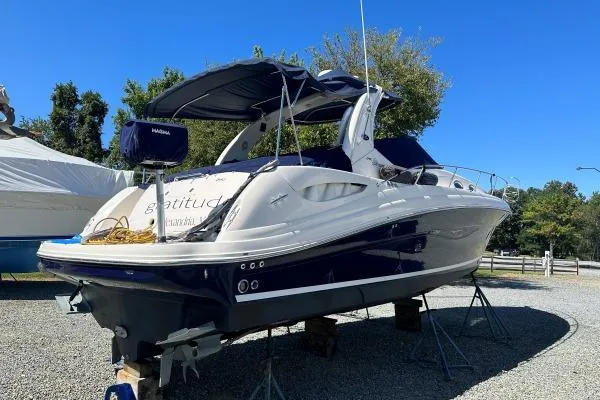 Slide: The Image of 2006 Sea Ray 340 Sundancer boat on stands, blue and white exterior, sunny day. - 6