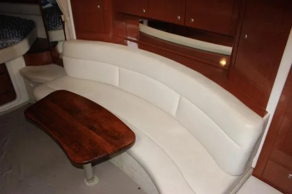 Slide: The Image of Luxurious interior of 2006 Sea Ray 340 Sundancer with curved seating and wooden table. - 8