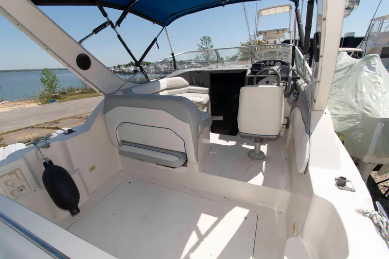 Slide: The Image of 1994 Bayliner 2855 Ciera boat interior with seating and steering wheel, docked near water. - 2