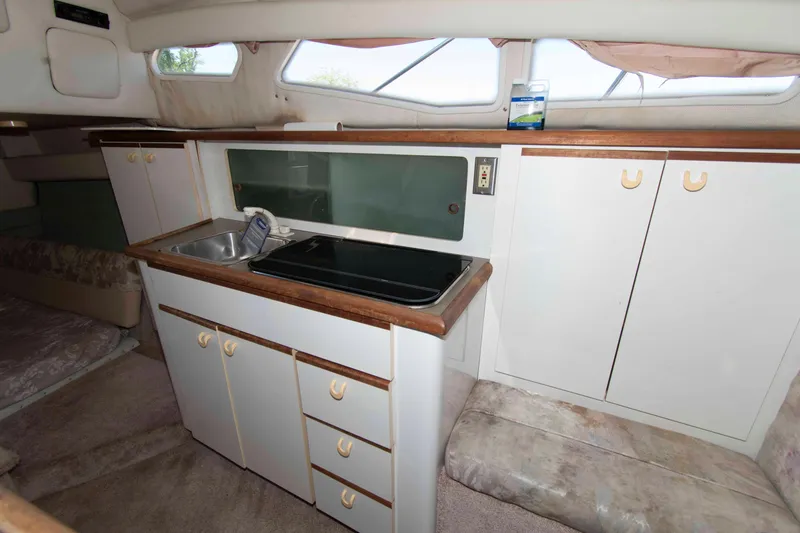 Slide: The Image of 1994 Bayliner 2855 Ciera boat interior with kitchenette, sink, and storage cabinets. - 7
