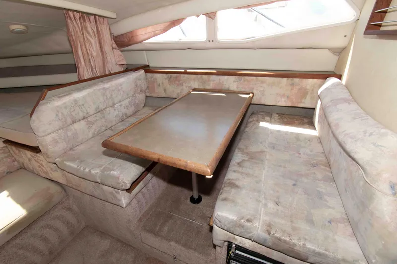 Slide: The Image of Interior of a 1994 Bayliner 2855 Ciera boat with dining area and seating. - 8