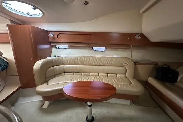 Slide: The Image of Interior of 2003 Four Winns 378 Vista yacht with beige leather seating and wooden table. - 13