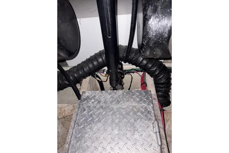 Slide: The Image of Engine compartment of a 2003 Four Winns 378 Vista boat, featuring metal flooring and wiring. - 18