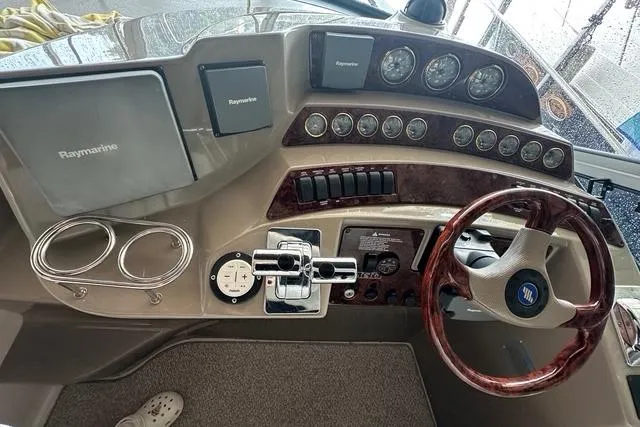 Slide: The Image of 2003 Four Winns 378 Vista boat dashboard with Raymarine electronics and wooden steering wheel. - 4