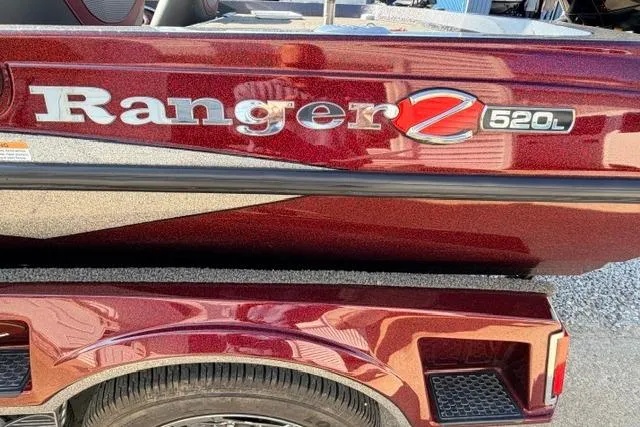 Slide: The Image of 2021 Ranger Z520L Cup-Equipped boat, maroon finish, close-up view of logo and trailer. - 32
