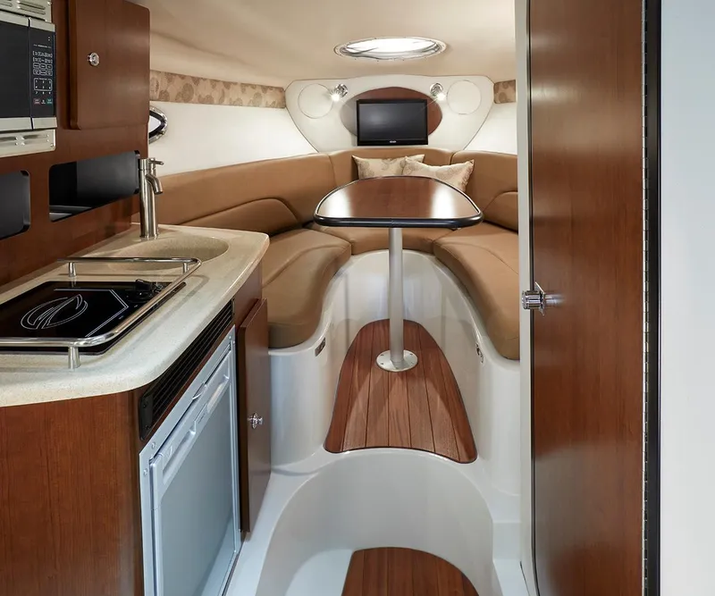 Slide: The Image of 2023 Crownline 270 CR cabin interior with kitchenette, seating, and table. - 31