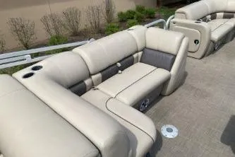 Slide: The Image of 2023 Sun Tracker SportFish 22 DLX boat interior with beige seating and cup holders. - 4