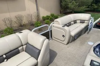 Slide: The Image of 2023 Sun Tracker SportFish 22 DLX pontoon boat with beige seating and spacious deck. - 5