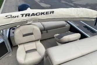 Slide: The Image of 2023 Sun Tracker SportFish 22 DLX boat interior with beige seating and cover. - 6