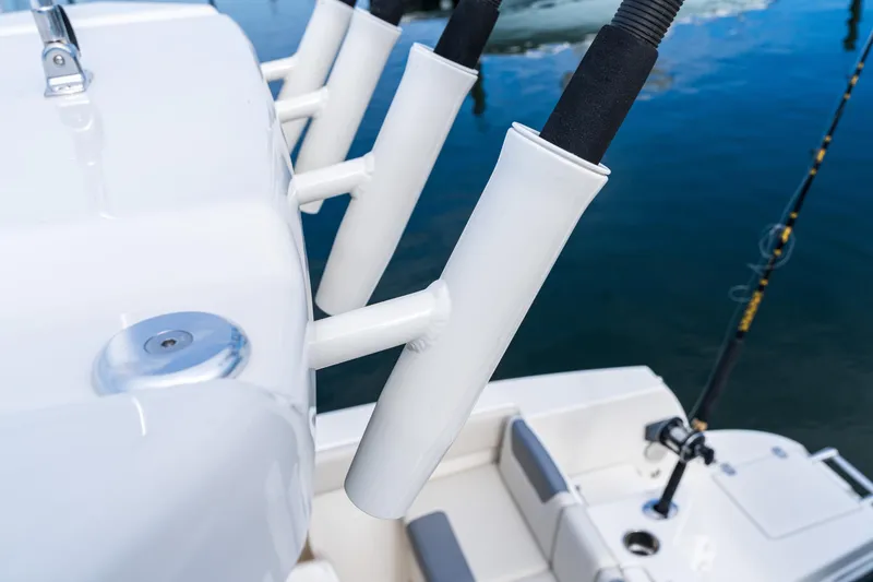 Slide: The Image of Fishing rod holders on a 2027 Sailfish 232 CC boat, docked on calm water. - 10