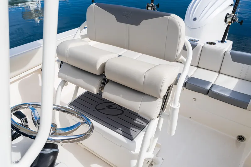 Slide: The Image of 2027 Sailfish 232 CC boat interior with cushioned seating and steering wheel. - 11