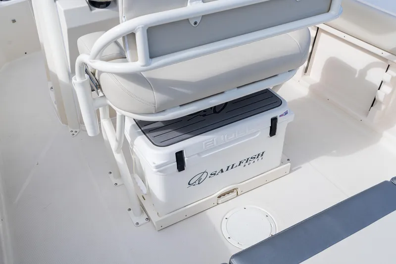 Slide: The Image of 2027 Sailfish 232 CC boat interior with cushioned seating and branded cooler. - 13
