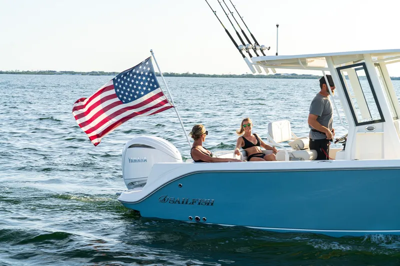 Slide: The Image of 2027 Sailfish 232 CC boat cruising with American flag on open water. - 24