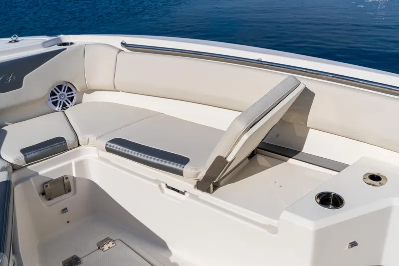 Slide: The Image of 2027 Sailfish 232 CC boat interior with cushioned seating and cup holder by the water. - 5