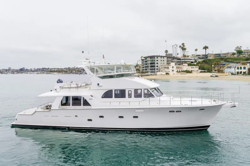 The Image of 2006 Cheoy Lee 72' Raised Pilot House yacht cruising near a coastal shoreline. - 0