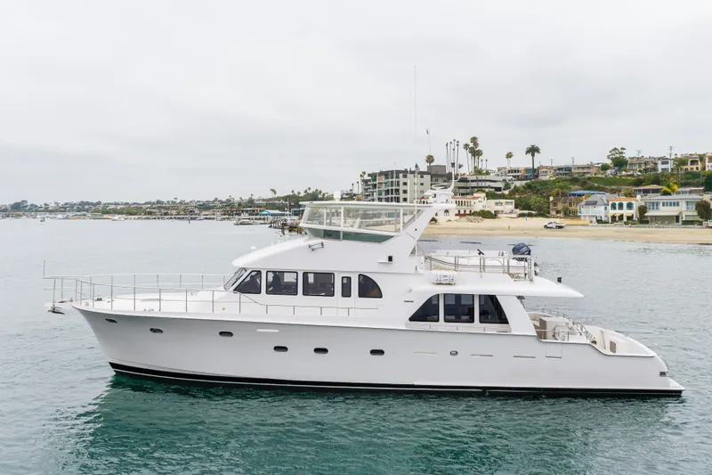 Slide: The Image of 2006 Cheoy Lee 72' Raised Pilot House yacht cruising near a coastal shoreline. - 66