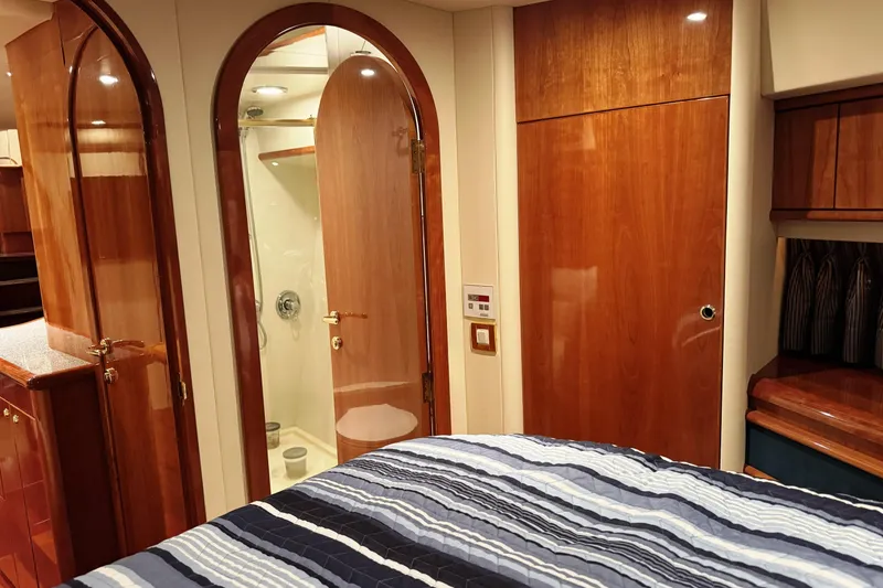Slide: The Image of Luxurious interior of 2001 Neptunus 56 Express yacht with wood finishes and striped bedding. - 39