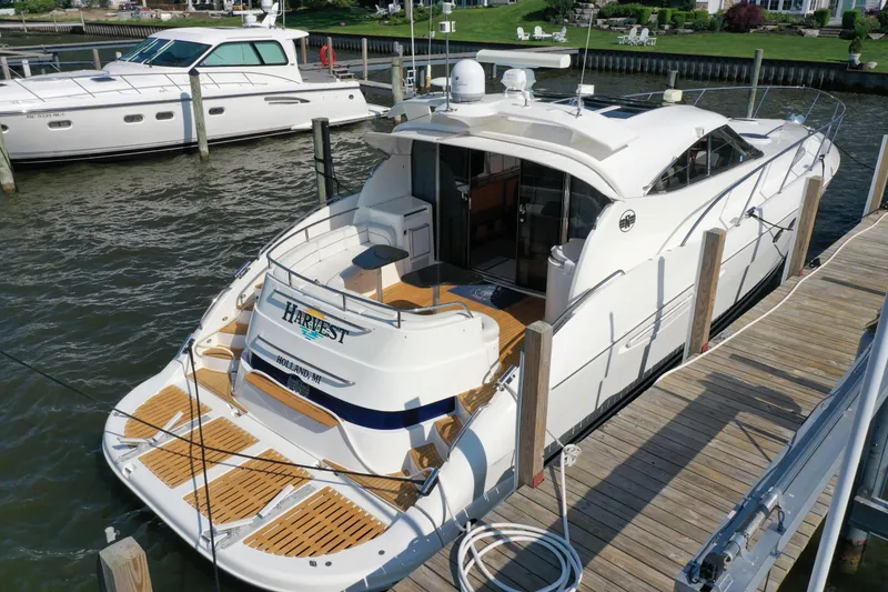 Slide: The Image of 2001 Neptunus 56 Express yacht docked, featuring sleek design and spacious deck area. - 4