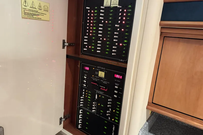 Slide: The Image of Electrical panel inside a 2001 Neptunus 56 Express yacht, showing switches and indicators. - 41