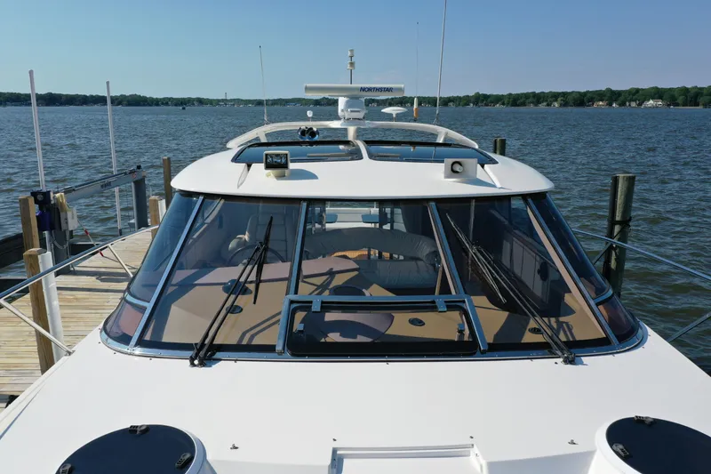 Slide: The Image of 2001 Neptunus 56 Express yacht docked by a serene lake. - 7