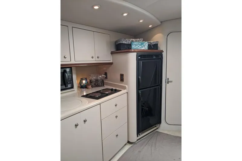 Slide: The Image of 1999 Cruisers Yachts 3870 Esprit kitchen with stove, fridge, and cabinets. - 16