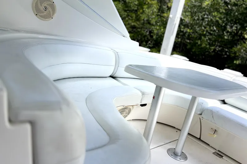 Slide: The Image of 1999 Cruisers Yachts 3870 Esprit interior with white seating and table, surrounded by greenery. - 20