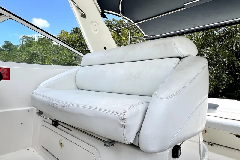 Slide: The Image of White leather seating on 1999 Cruisers Yachts 3870 Esprit, with lush greenery in the background. - 25