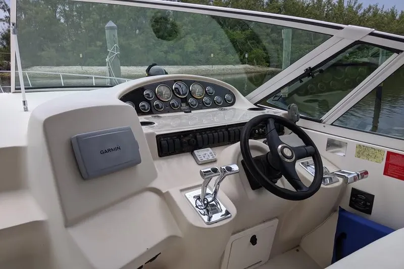 Slide: The Image of 1999 Cruisers Yachts 3870 Esprit docked, featuring sleek design and spacious deck area. - 3