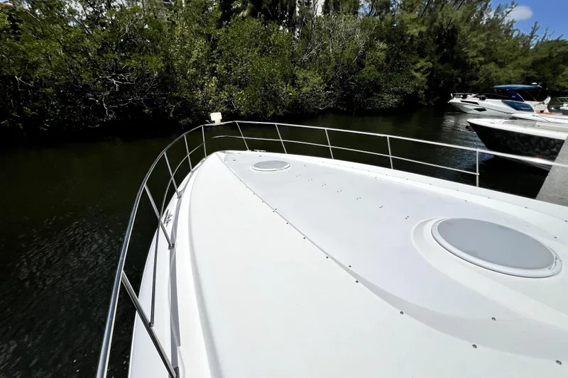 Slide: The Image of 1999 Cruisers Yachts 3870 Esprit on calm water, surrounded by lush greenery. - 37